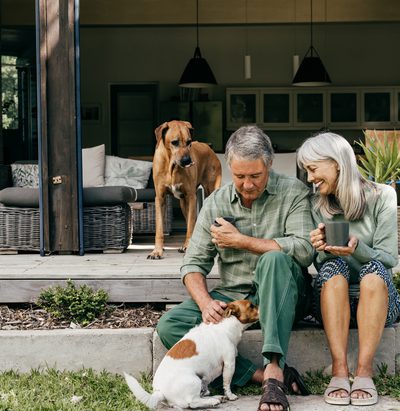 The warmth of companionship shines as a couple in their 60s enjoys a slow morning, sipping coffee in the fresh air.
