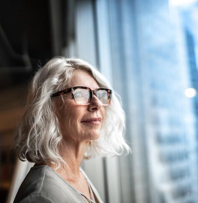 Mature businesswoman looking out of window.